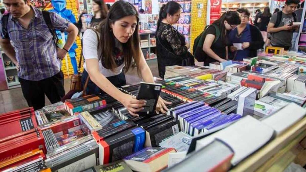 Mujer viendo libros en Filsa. Foto: Cámara Chilena del Libro. BY-NC